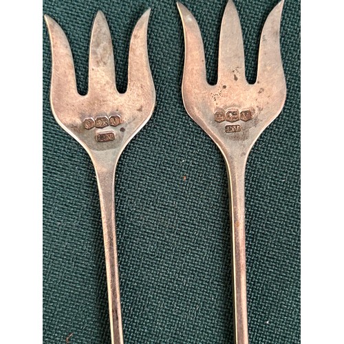 24 - A pair of sterling silver pickle or olive forks, Sheffield 1938 by Viners Ltd, with mother of pearl ... 