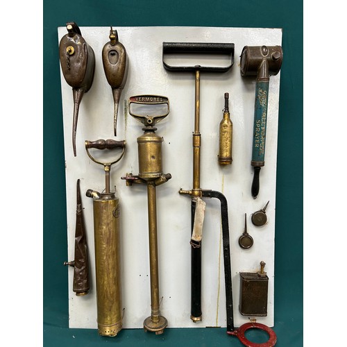 380 - Display board with collection of antique & vintage oil cans, sprayers, stirrup pump, WW1 Shand Mason... 