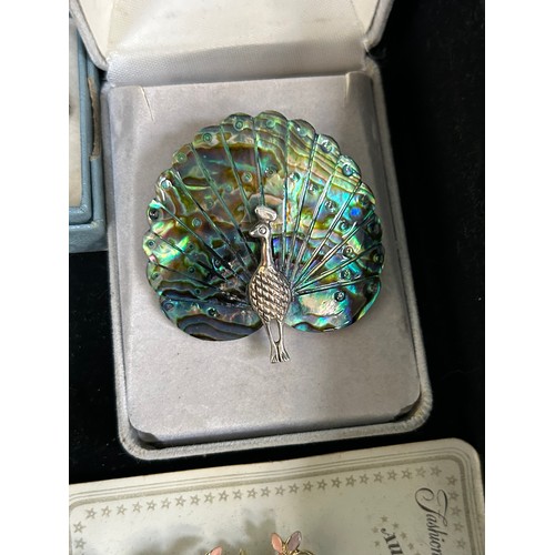 66 - A jewellery box with contents of vintage brooches to include a mother of pearl peacock, a gilt & dia... 