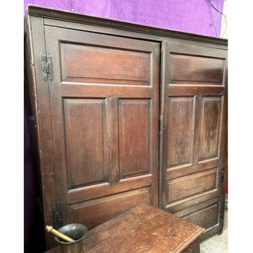 521 - A very large antique oak Housekeepers cupboard from a Norfolk country house. The doors each with fou... 