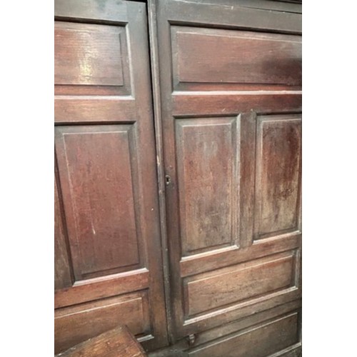 521 - A very large antique oak Housekeepers cupboard from a Norfolk country house. The doors each with fou... 