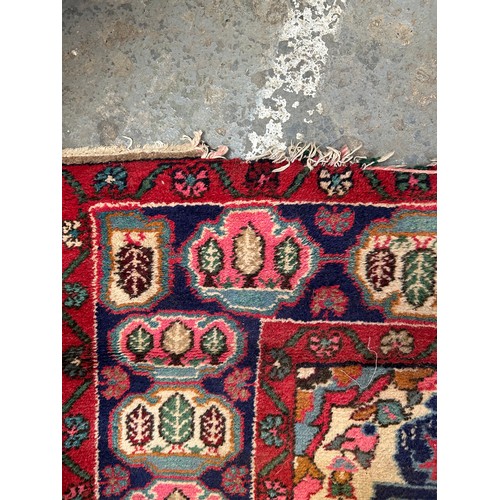 287 - Large Vintage Persian Hamadan carpet with central medallion in reds and blue against a paler field. ... 