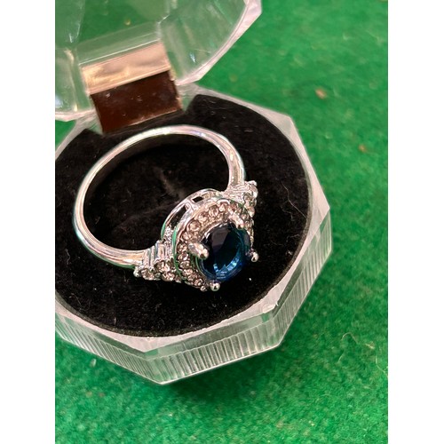 14 - STYLISH SILVER METAL RING SET WITH LARGE OVAL SAPPHIRE COLOURED STONE SURROUNDED BY DIAMANTE - SIZE ... 