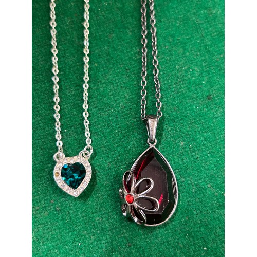 26 - TWO MODERN NECKLACES, ONE WITH PEAR SHAPED RED CRYSTAL AND FLOWER PENDANT, THE OTHER WITH EMERALD GR... 