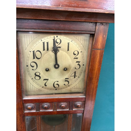 275 - A 1920's wall clock with Art Deco style face, in a mahogany case, by Badische Germany, with pendulum... 