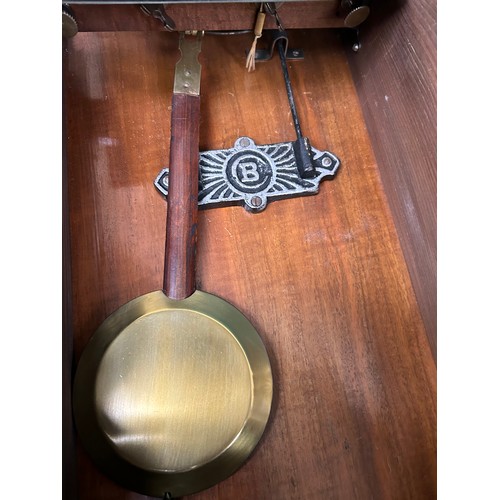 275 - A 1920's wall clock with Art Deco style face, in a mahogany case, by Badische Germany, with pendulum... 