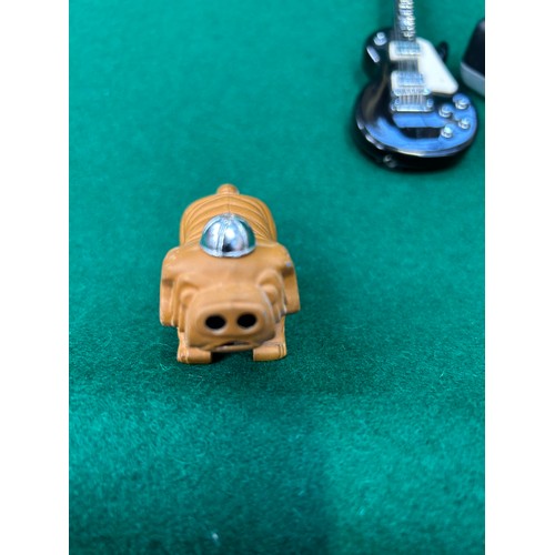 116 - Three novelty cigarette lighters including a bulldog with cap,  a guitar by Dora, and a miniature ca... 