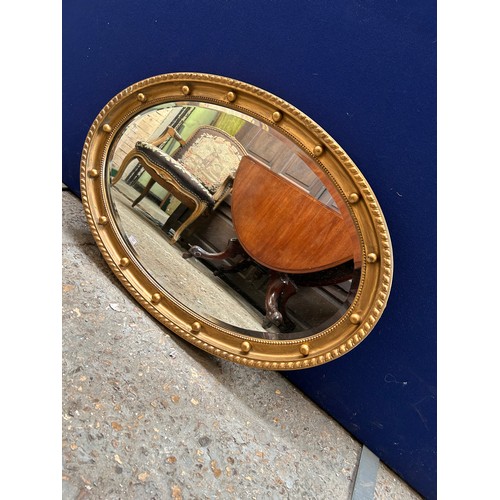 429 - Regency style oval mirror, bevel edged, the gilt frame with gadrooning & ball decoration. 80cm x 52c... 