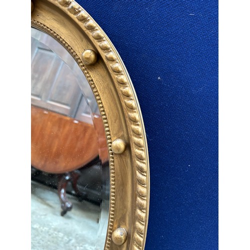 429 - Regency style oval mirror, bevel edged, the gilt frame with gadrooning & ball decoration. 80cm x 52c... 