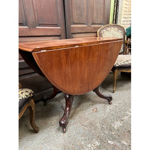 423 - Victorian mahogany drop leaf table on turned pedestal with four splayed carved legs with pot castors... 