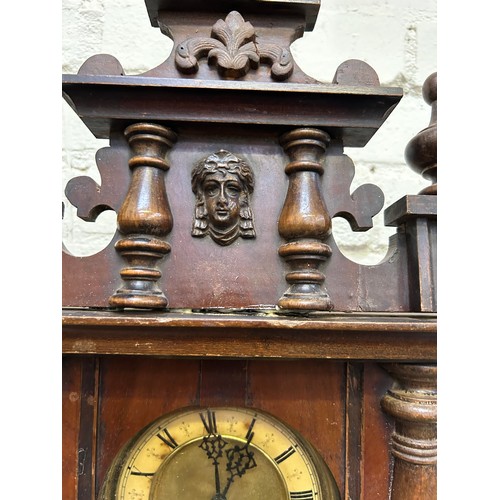 271 - A Victorian Vienna style wall clock, the face with roman numerals. With pendulum & key. Needs attent... 