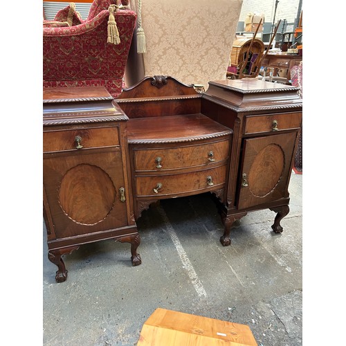 468 - A large 1920's Mahogany Sideboard with two central bow fronted drawers flanked by cupboards on cabri... 