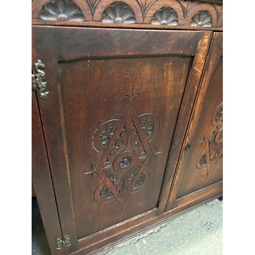 460 - Old Charm style oak cupboard with carved panel doors & internal shelves. W 37” x 14” x 36”