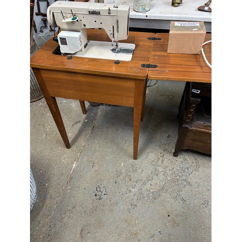 456 - 1970's sewing machine and walnut veneered table by Hereward complete with instructions, accessories ... 