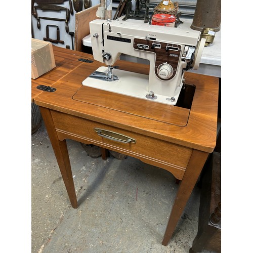 456 - 1970's sewing machine and walnut veneered table by Hereward complete with instructions, accessories ... 