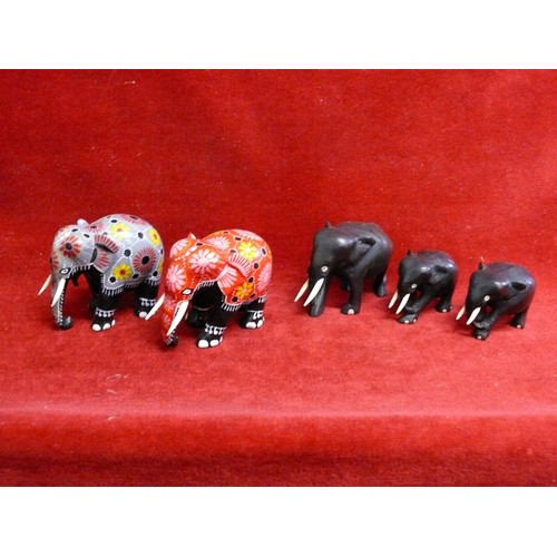 77 - 3 EBONISED ELEPHANT FIGURES AND 2 BATIK WOODEN ELEPHANTS