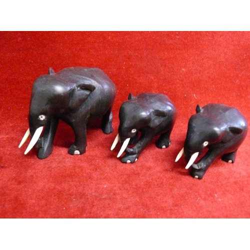 77 - 3 EBONISED ELEPHANT FIGURES AND 2 BATIK WOODEN ELEPHANTS