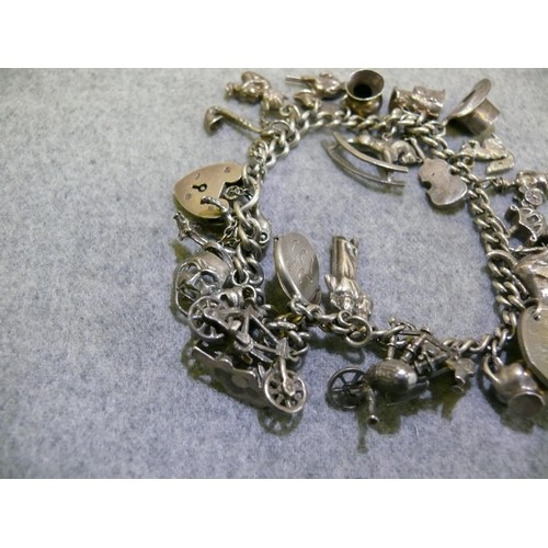 24 - HALLMARKED STERLING SILVER CHARM BRACELET WITH 25 CHARMS MANY MARKED SILVER TOTAL WEIGHT 62.7 GRMS