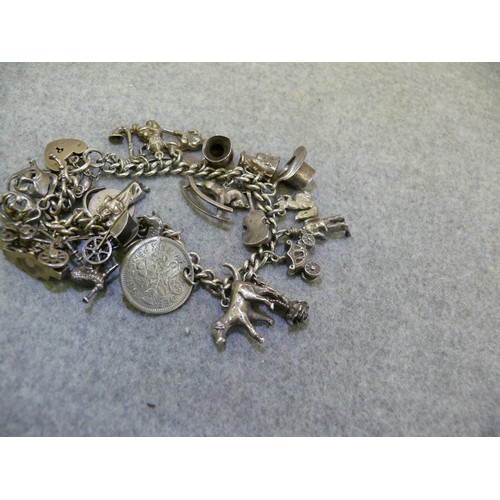 24 - HALLMARKED STERLING SILVER CHARM BRACELET WITH 25 CHARMS MANY MARKED SILVER TOTAL WEIGHT 62.7 GRMS