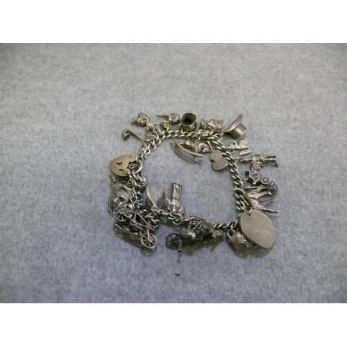 24 - HALLMARKED STERLING SILVER CHARM BRACELET WITH 25 CHARMS MANY MARKED SILVER TOTAL WEIGHT 62.7 GRMS