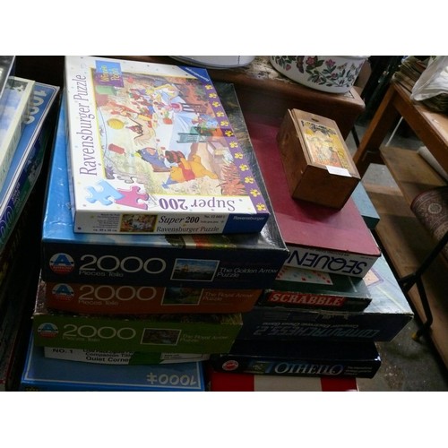 243 - A STACK OF VINTAGE GAMES TO INCLUDE MONOPOLY, SCRABBLE ETC PLUS A STACK OF JIGSAW PUZZLES