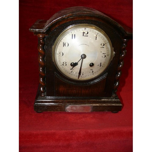 81 - AN OAK CASED 30 DAY CHIMING CLOCK WITH BARLEY TWIST DETAIL AND ENGRAVED CARTOUCHE BY WALKER AND HALL... 