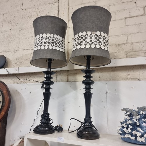 84 - MATCHING PAIR OF EBONISED TURNED TABLE LAMPS,  WITH GREY SHADES TRIMMED WITH CREAM LACE, BOTH IN VER... 