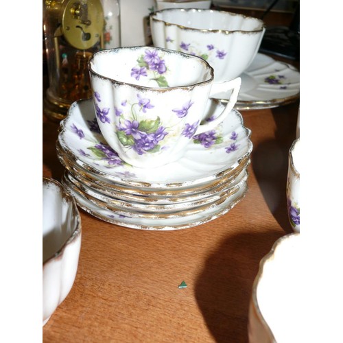 115 - A DELICATE CHINA PART DINNER SET ADORNED WITH VIOLETS, 2 PLATTERS, 12 TEA PLATES, 6 SAUCERS, 9 CUPS ... 