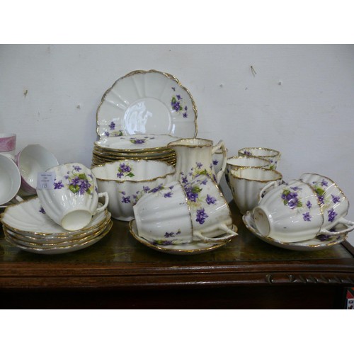 115 - A DELICATE CHINA PART DINNER SET ADORNED WITH VIOLETS, 2 PLATTERS, 12 TEA PLATES, 6 SAUCERS, 9 CUPS ... 