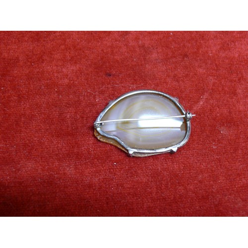 33 - SLICE OF BROWN AGATE MOUNTED ON A SILVER BROOCH