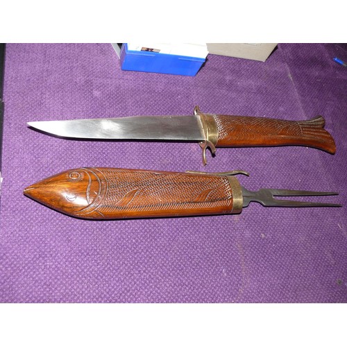 90 - INDIAN BRASS HILTED CARVING KNIFE AND MEAT FORK WITH CARVED HARDWOOD FISH HANDLES IN VERY GOOD CONDI... 