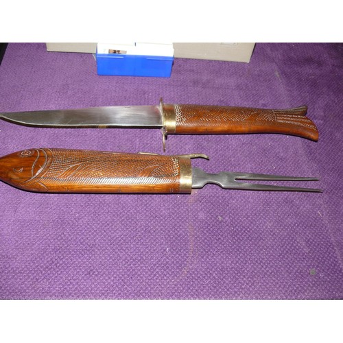 90 - INDIAN BRASS HILTED CARVING KNIFE AND MEAT FORK WITH CARVED HARDWOOD FISH HANDLES IN VERY GOOD CONDI... 