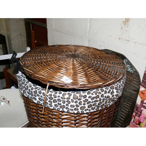 375 - A WICKER LAUNDRY BASKET WITH LEOPARD PRINT LINING AND CONTENTS OF COAT HANGERS