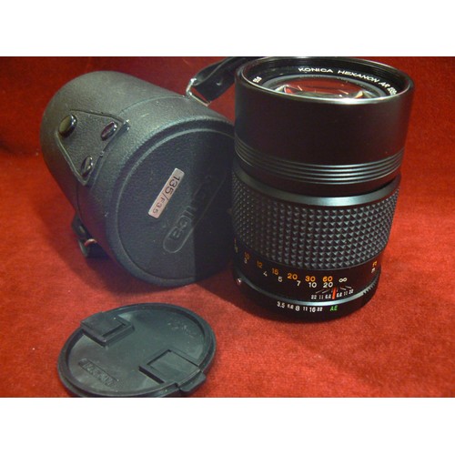 4 - A vintage Konica 135mm camera lens with protective case.