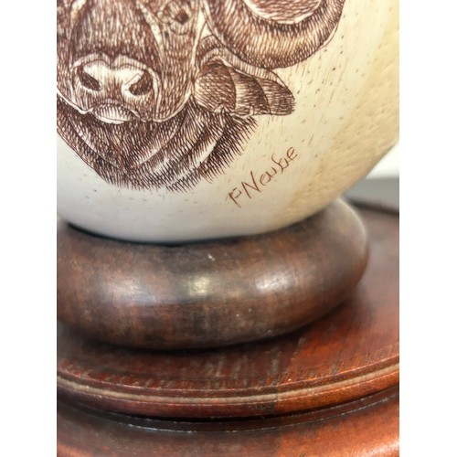 2 - OSTRICH EGG ENGRAVED AND HANDPAINTED WITH AFRICAN WILDLIFE, SIGNED F NAUBE ON A WOODEN STAND