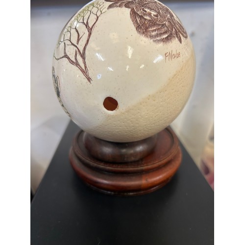 2 - OSTRICH EGG ENGRAVED AND HANDPAINTED WITH AFRICAN WILDLIFE, SIGNED F NAUBE ON A WOODEN STAND