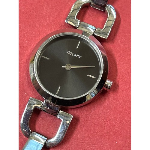 25 - SMART CONTEMPORARY STYLE DKNY WATCH ON POLISHED STEEL STRAP, BLACK DIAL