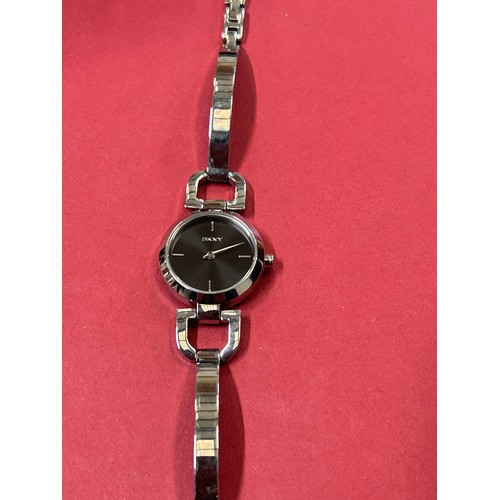 25 - SMART CONTEMPORARY STYLE DKNY WATCH ON POLISHED STEEL STRAP, BLACK DIAL