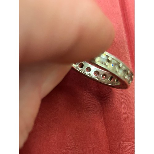 32 - 925 SILVER ETERNITY RING SET WITH CLEAR STONES THE SQUARE BAND ENGRAVED WITH LEAF DESIGN. SIZE M/N