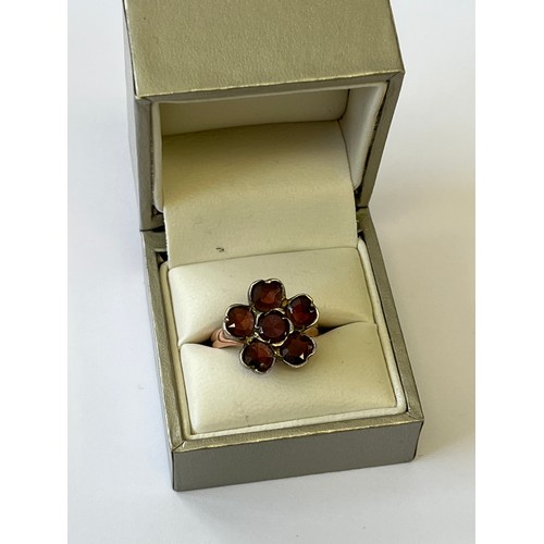 7 - A 9CT GOLD AND GARNET FLOWER HEAD RING WITH SILVER BACKED SETTIG, WEIGHT 5GR SIZE O (TESTED NOT MARK... 