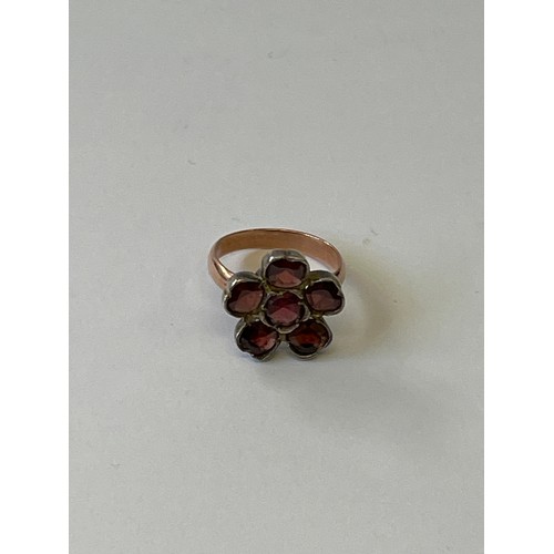 7 - A 9CT GOLD AND GARNET FLOWER HEAD RING WITH SILVER BACKED SETTIG, WEIGHT 5GR SIZE O (TESTED NOT MARK... 