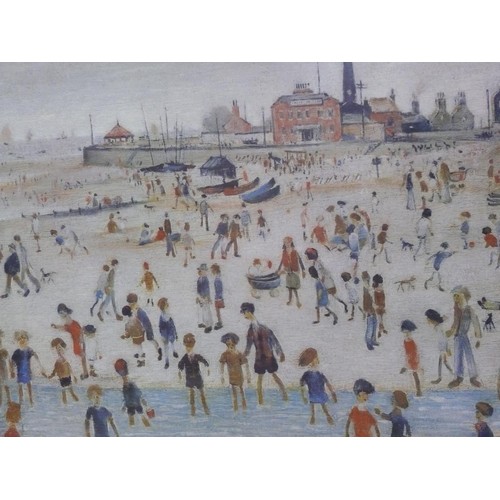 506 - Framed art print - 'At The Seaside' by Laurence Stephen Lowry. In a gilt frame 67cm x 56cm.