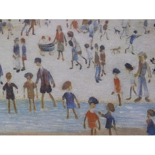 506 - Framed art print - 'At The Seaside' by Laurence Stephen Lowry. In a gilt frame 67cm x 56cm.