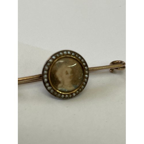 11 - A GOLD BAR BROOCH WITH HAND PAINTED FEMALE  FACE WITH SEED PEARLS MAY BE MOURNING BROOCH