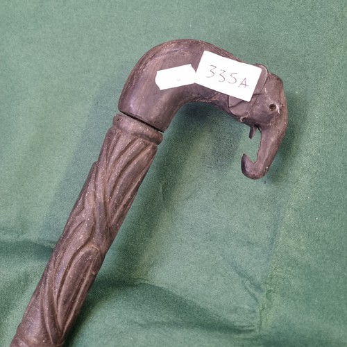 335A - African ebonised walking stick with carved elephants head handle.