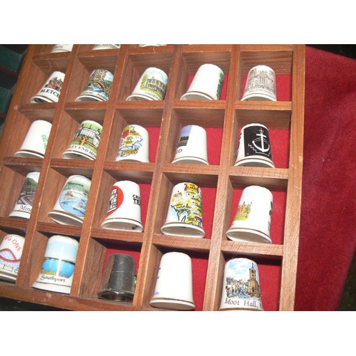 292 - LARGE COLECTION OF MOSTLY CERAMIC THIMBLES WITH DISPLAY CASES PLUS SOUVENIR SPOONS ON A WALL RACK