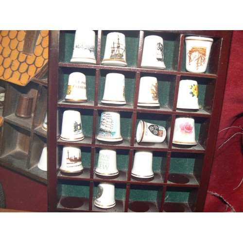 292 - LARGE COLECTION OF MOSTLY CERAMIC THIMBLES WITH DISPLAY CASES PLUS SOUVENIR SPOONS ON A WALL RACK