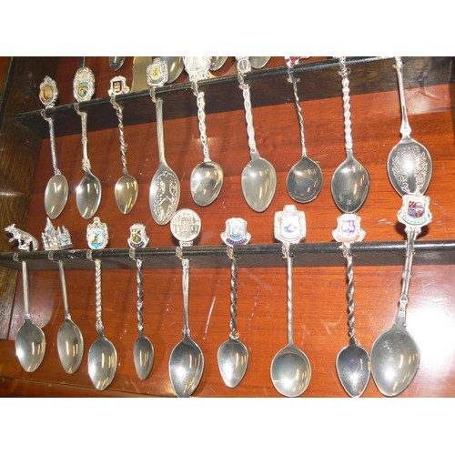 292 - LARGE COLECTION OF MOSTLY CERAMIC THIMBLES WITH DISPLAY CASES PLUS SOUVENIR SPOONS ON A WALL RACK