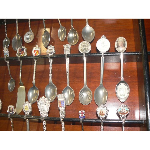 292 - LARGE COLECTION OF MOSTLY CERAMIC THIMBLES WITH DISPLAY CASES PLUS SOUVENIR SPOONS ON A WALL RACK