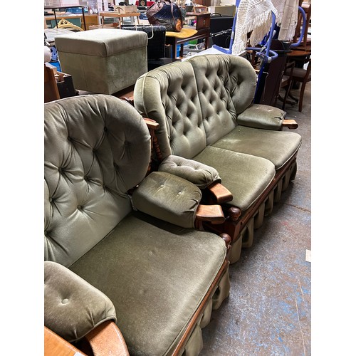 407 - A VERY COMFORTABLE TWO SEATER WOODEN FRAMED SOFA IN GREEN DRALON, BUTTONED BACKS AND ARM RESTS. WITH... 